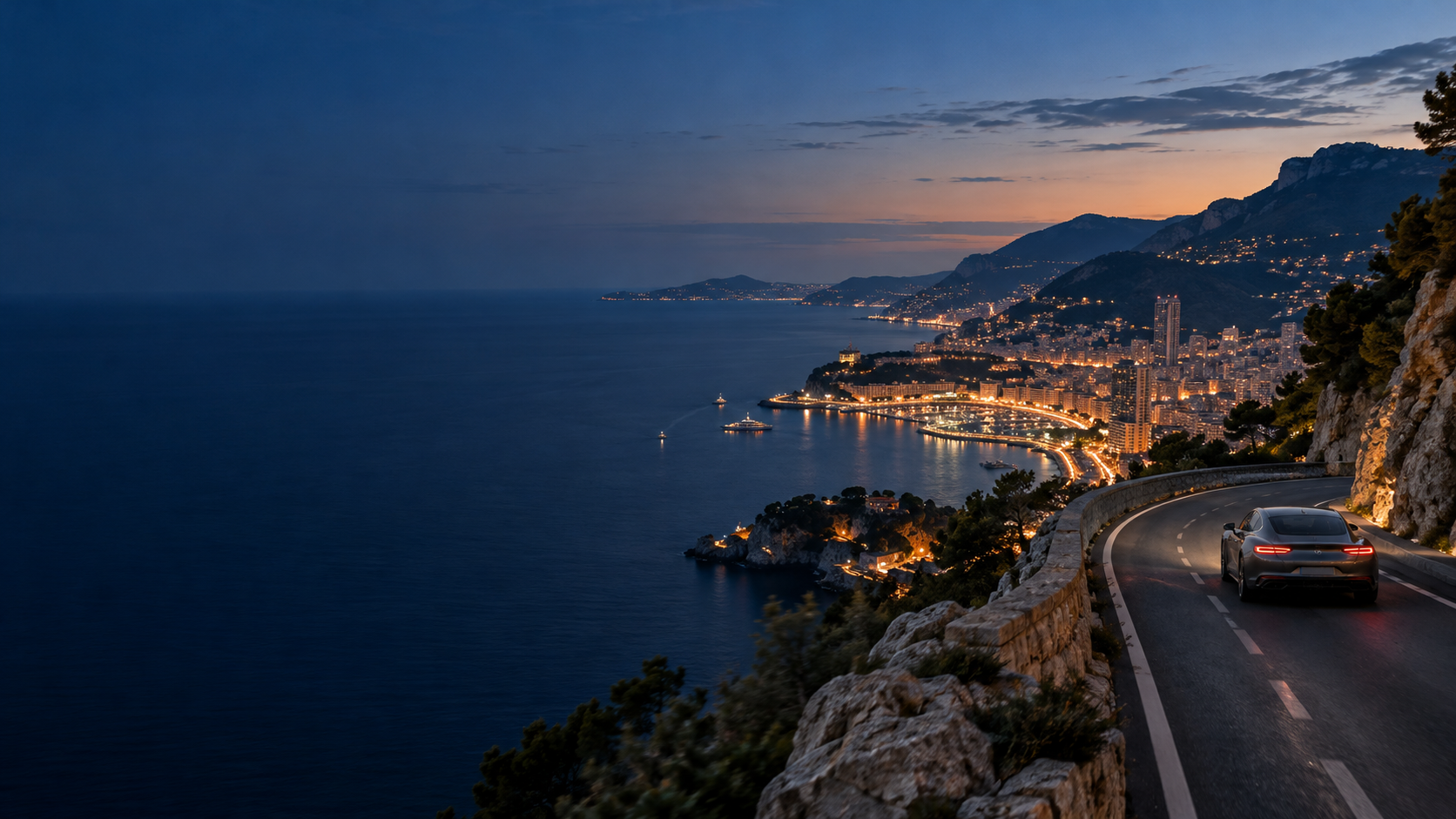A car on a coastal road overlooking the French Riviera at dusk